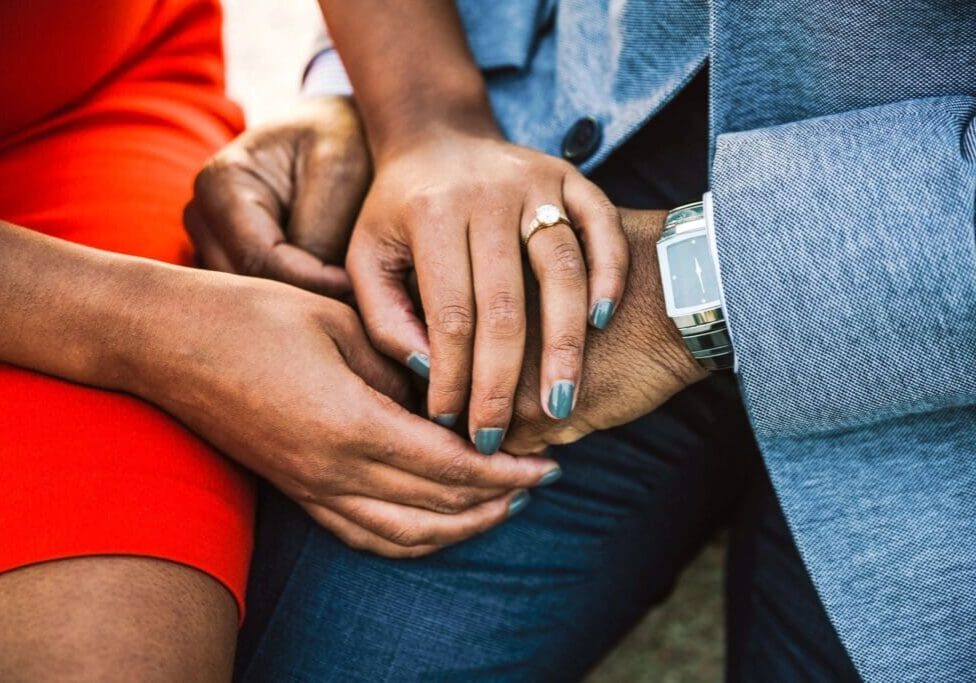 A close up of two people holding hands