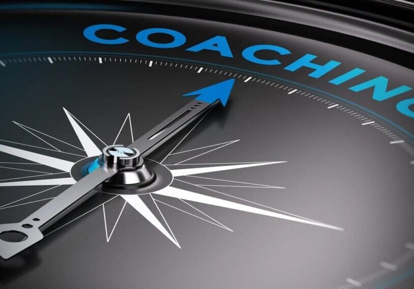 A close up of the word coach on a compass